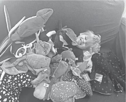  ?? IMAGES PROVIDED ?? Tiffany Holloway's son, Jonas, is seen playfully buried underneath some of the stuffed sea creature animals sent to him for his birthday after a post of his mother's handmade manta ray went viral on Reddit.