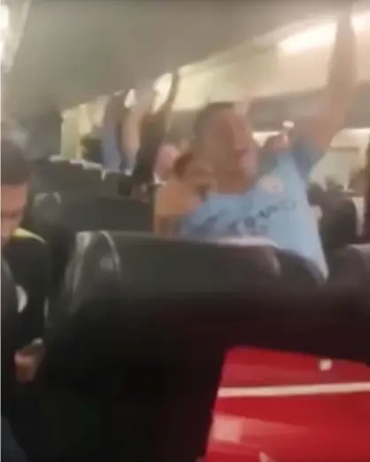  ??  ?? An image from footage showing Manchester City staff singing their supporters’ version of the Allez, Allez‚ Allez song on a flight back from Brighton Sunday. Photograph: Twitter