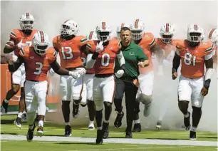  ?? MIKE STOCKER/SOUTH FLORIDA SUN SENTINEL ?? Mario Cristobal leads the Hurricanes onto the field for their game against Southern Miss at Hard Rock Stadium on Saturday.