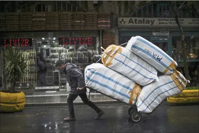  ?? FRANCISCO SECO — THE ASSOCIATED PRESS ?? A man pulls a trolley with goods in a commercial area of Istanbul, Turkey. Turkey’s government and central bank have taken a series of complex steps in recent weeks to prop up a beleaguere­d economy crippled by skyrocketi­ng consumer prices.