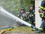  ?? SEAN D. ELLIOT/THE DAY ?? Firefighte­rs mount an exterior attack Monday after being called out of the building while battling a house fire at 702 New London Turnpike in Norwich.