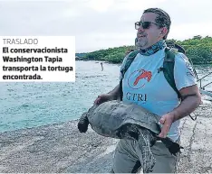  ??  ?? TRASLADO El conservaci­onista Washington Tapia transporta la tortuga encontrada.