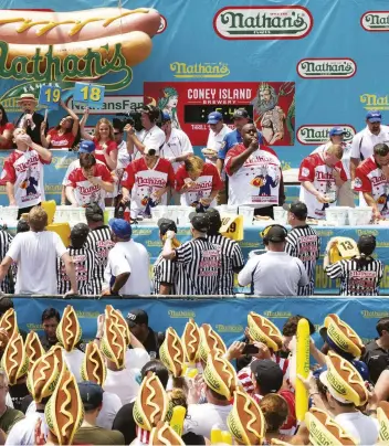  ??  ?? ABOVE Fans cheer at the 2019 Nathan’s Famous Internatio­nal Hot Dog Eating Contest