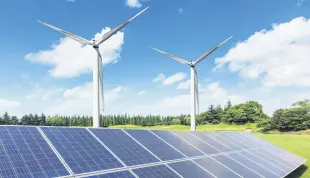  ?? ?? Solar panels and wind turbines installed in a field.