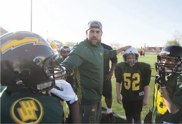  ?? TOPHER SEGUIN/EDMONTON JOURNAL ?? Ryan King of the Edmonton Eskimos organizes young players during the 2015 Eskimos Amateur Football Camp held at Clarke Stadium. The team recognized King Tuesday for his contributi­ons to the community with the annual David Boone Award. King says that...