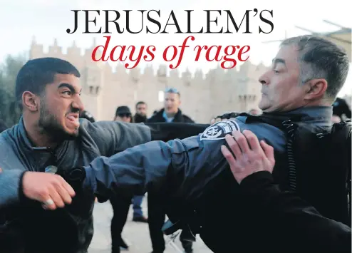  ?? MENAHEM KAHANA / AFP / GETTY IMAGES ?? An Israeli police officer fights with a Palestinia­n protester outside Damascus Gate in Jerusalem's Old City on Thursday.