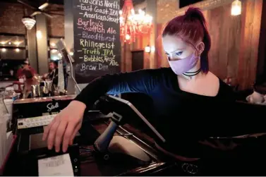  ?? COURTNEY HERGESHEIM­ER/COLUMBUS DISPATCH ?? Kahlan Feichtenbe­iner-franson puts in a food order at Pat and Gracie’s on East Gay Street. The restaurant has been running with just seven staff members.