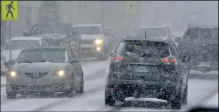  ?? TINA COMEAU ?? Vehicles navigate a snow-covered street in Yarmouth, N.S., in March.