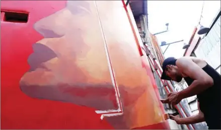  ?? PHA LINA ?? Nepali artist Kiran Maharjan paints a wall down an alley off Street 240 on Wednesday.