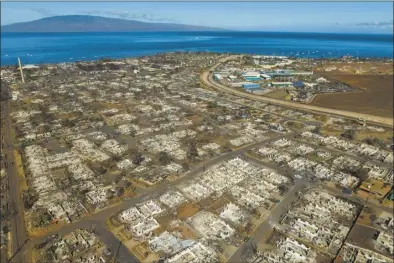  ?? AP file photo ?? The aftermath of a wildfire is visible in Lahaina, Hawaii on Aug. 17. Hawaii Gov. Josh Green’s administra­tion had budgeted $199 million for Maui wildfire recovery expenses but are now expecting they may need $561 million under a “worst-case” scenario, the Honolulu Star-Advertiser reported on Wednesday.