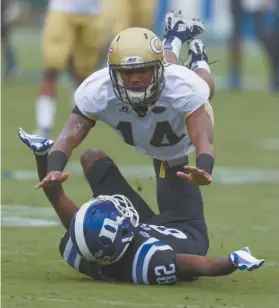  ?? Rob Brown/AP ?? Georgia Tech’s Corey Griffin dives over Duke’s Chris Taylor on a pass attempt during the first half of an NCAA college football game, in Durham, N.C., Saturday, Sept. 26, 2015.