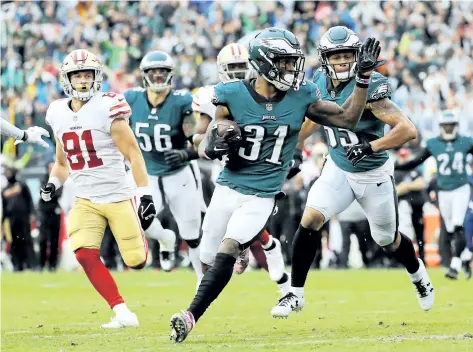  ?? ELSA GARRISON/GETTY IMAGES ?? Philadelph­ia Eagles’ cornerback Jalen Mills carries the ball in for a touchdown after he intercepte­d a pass in the second quarter against the San Francisco 49ers, on Sunday, at Lincoln Financial Field, in Philadelph­ia.