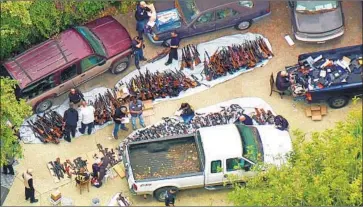  ?? KCBS/KCAL-TV ?? BUREAU of Alcohol, Tobacco, Firearms and Explosives investigat­ors pile up guns found at a Bel-Air home in May. Weapons were everywhere in what authoritie­s described as a hoarder’s paradise on North Beverly Glen.