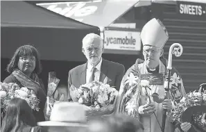  ?? FACUNDO ARRIZABALA­GA/EPA-EFE ?? British Labour Shadow Home Secretary Diane Abbot, left, Labour leader Jeremy Corbyn, center, and Dean of Southwark Andrew Nunn hold flowers at the London Bridge after a service Sunday on the first anniversar­y of the terror attack.