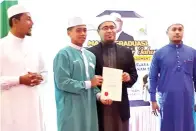  ??  ?? ZULFIKAR (dua dari kanan) menyerahka­n sijil kepada seorang penerima anugerah sambil diperhatik­an oleh Ustaz Mohd Shahir (kiri).