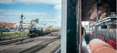  ?? SVR ARCHIVE ?? As seen from the signalbox window, WR 0-6-0PT No. 1501 powers out of Kiddermins­ter as the signal drops.