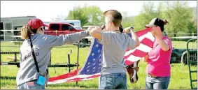  ?? SUBMITTED PHOTO ?? Members of Lincoln Riding Club’s precision drill team known as ‘The Regulators’ and participan­ts in an April 29 clinic conducted by the team fold an American flag. ‘The Regulators’ proudly carry the U.S. and other flags on horseback during rodeo performanc­es.