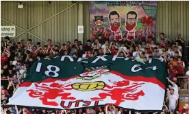  ?? Photograph: Matthew Ashton/AMA/Getty ?? Fans hold the Wrexham flag under a banner of Rob McElhenney and Ryan Reynolds during the match against Doncaster in September.