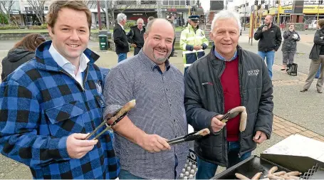  ?? JOHN HAWKINS/ STUFF ?? Clutha-Southland MP Hamish Walker, left, and Mossburn farmers Jason Herrick and John Douglas on cook duties at a rally for mental health awareness in the rural sector in Invercargi­ll earlier this year.