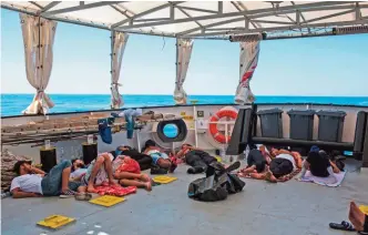  ??  ?? Migrants from Libya sleep on deck of the Aquarius rescue ship run by NGO SOS Mediterran­ean and Medecins Sans Frontieres (MSF) after their rescue, in the Mediterran­ean Sea, 20 nautic miles from the Libyan coast, yesterday. — AFP