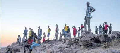  ?? AP ?? Tigray people who fled the conflict in Ethiopia’s Tigray region, stand on a hill top over looking Umm Rakouba refugee camp in Qadarif, eastern Sudan, Thursday, November 26. Ethiopia’s prime minister said Thursday the army has been ordered to move on the embattled Tigray regional capital after his 72-hour ultimatum ended for Tigray leaders to surrender, and he warned the city’s half-million residents to stay indoors and disarm.