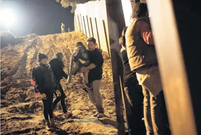  ?? PHOTO: REUTERS ?? Border breach . . . Migrants from Central America gather in San Diego County after crossing illegally from Mexico to the United States by jumping a border fence in Tijuana yesterday.