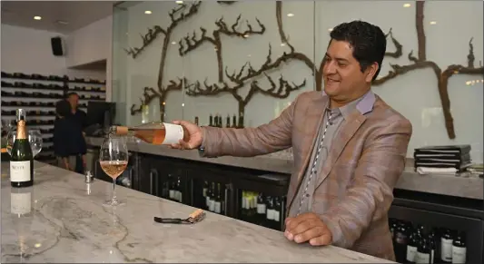  ?? PHOTOS BY JOSE CARLOS FAJARDO — BAY AREA NEWS GROUP ?? Wine director Jorge Tinoco pours a glass of 2018Wente Vineyards Pinot Noir Rose at Vineyard Table & Tasting Lounge in Livermore.