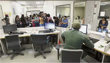  ?? — AP ?? Under process: A US Customs and Border Protection officer checking immigrants’ details at the foreigners processing facility in Brownsvill­e, Texas.