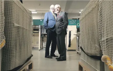  ?? JULIE OLIVER ?? Ronald Arends, left, CEO and president of the Canadian Bank Note Co., stands with brother Douglas, company chairman, in the printing room amid flats of sheets of $20 and $100 bills worth untold millions, in the basement of their Richmond Road firm.