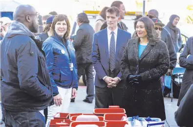  ?? Amy Osborne / Special to The Chronicle ?? Dr. Grant Colfax, the city’s new director of public health (center right), was just hours on the job when Mayor London Breed took him on a tour of the homelessne­ss health fair where he was quizzed on his priorities.