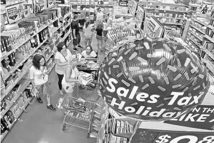  ?? RED HUBER/STAFF PHOTOGRAPH­ER ?? Customers at a Wal-Mart in the Lake Nona area shop for school supplies Friday during the tax-free holiday weekend which ends Sunday.