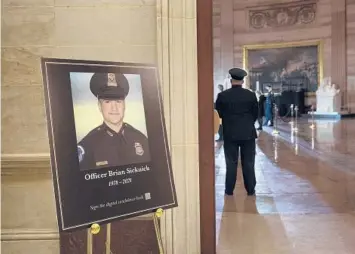  ?? BRENDAN SMIALOWSKI/AP ?? A placard in the Capitol Rotunda displays a photograph last month of Capitol Police Officer Brian Sicknick, who died after clashing with rioters in the Jan. 6 attack on the building. He died from his injuries the next day.