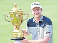  ?? AFP ?? Justin Harding holds the winner’s trophy.