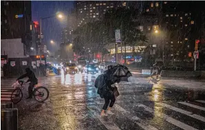  ?? The Associated Press ?? ■ People travel through a torrential downpour caused from the remnants of Hurricane Ida, near Columbus Circle on Sept. 1. As weather becomes more extreme and unpredicta­ble caused by climate change, transit officials say that more needs to be done to prepare the East Coast’s vital transit systems.