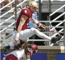  ??  ?? GETTING UP THERE: Trae Barry hurdles Colgate’s Keshaun Dancy on his way to the end zone during the second quarter.