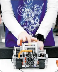  ??  ?? A student focuses on the robot’s performanc­e during the tournament.