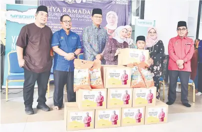  ?? — Gambar Penerangan ?? RINGANKAN BEBAN: Nancy menyampaik­an sumbangan Ramadan kepada salah seorang penerima pada Program Ilya Ramadan dan Sumbangan Ramadan Kawasan Parlimen Santubong, semalam. Turut kelihatan, Dr Abdul Rahman (tiga kiri).