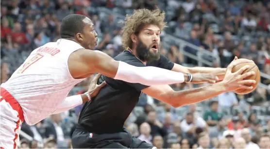  ?? | JOHN BAZEMORE/ AP ?? Center Robin Lopez feels the pressure fromHawks center Dwight Howard in the first half of the Bulls’ loss to the Hawks on Friday in Atlanta.