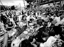  ?? ALEJANDRO TAMAYO/SAN DIEGO UNION TRIBUNE ?? Volunteers hand out meals Monday at El Chapparal border crossing in Tijuana, Mexico, where about 200 people from Central America are hoping to gain asylum in the U.S.