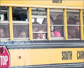  ?? "1 1)050 ?? A Townville Elementary student looks out of the window of a school bus as she and her classmates are transporte­d to Oakdale Baptist Church following a shooting at Townville Elementary.