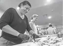  ?? JOEL ANGEL JUAREZ/THE REPUBLIC ?? Gina Montion, left, and Autumn Palik, volunteers with Esperança Inc., prepare food at the organizati­on’s headquarte­rs in Phoenix on Tuesday.