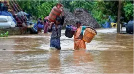  ?? PTI ?? Villagers wade through a flood affected area following heavy rains induced by Cyclone Gulab in Visakhapat­nam on Monday. —