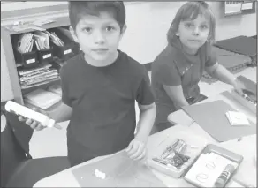  ??  ?? Landscape: Northwest first-graders Logan Soriano and Samantha Baggott make a three-dimensiona­l winter landscape.