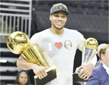  ?? (Photo: AFP) ?? Giannis Antetokoun­mpo of Milwaukee Bucks holds the Bill Russell NBA Finals MVP Award and Larry O’brien Trophy after the Bucks defeated Phoenix Suns in Game Six to win the 2021 NBA Finals at the Fiserv Forum Center in Milwaukee, Wisconsin on Tuesday, July 20, 2021.