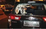  ?? JOS RIZAL/JAWA POS ?? KACA PECAH: Mobil Kijang Innova yang menyerempe­t supeltas. Jendela belakang bolong karena dilempar benda keras.