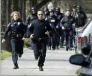  ??  ?? In a April 16, 2007photo, Blacksburg police officers run from Norris Hall on the Virginia Tech campus in Blacksburg, Va. as multiple shootings occur at the engineerin­g building.