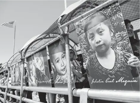  ?? Mario Tama / Getty Images ?? Activists hold photos of migrant children who died trying to cross the U.S.-Mexico border as they demonstrat­e while standing on the Paso Del Norte Port of Entry bridge in Ciudad Juarez, Mexico.