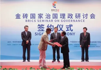  ??  ?? Representa­tives of the China Internatio­nal Publishing Group and the Institute of Europe, Russian Academy of Sciences, exchange copies of the memorandum signed during the BRICS Seminar on Governance in Quanzhou, Fujian Province, on August 18. The...