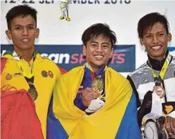  ?? [ FOTO BERNAMA ] ?? Muhammad Hazirul (tengah) bersama pemenang pingat perak dan gangsa acara 62 kilogram clean and jerk lelaki.