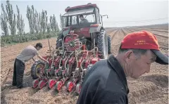  ??  ?? Zheng Chenggong, 27, and his parents have amassed more than 160 acres by renting plots from the local government and other villagers who have given up full-time farming.